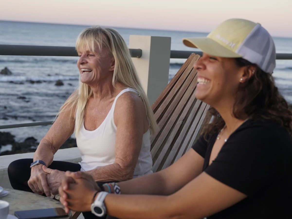 Joss Alabi and a returning guest talking by the ocean during a one to one coaching session